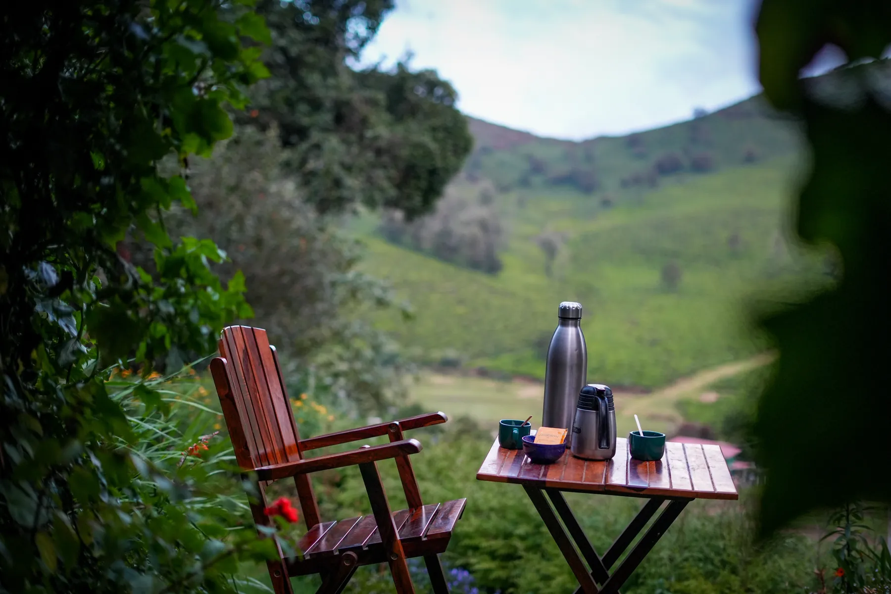 Tea and coffee on a wooden table, looking out over the tea slopes